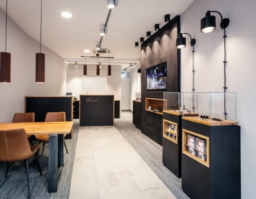 Modernes Optikergeschäft mit Vitrinen, Beratungstischen und stilvoller Beleuchtung.